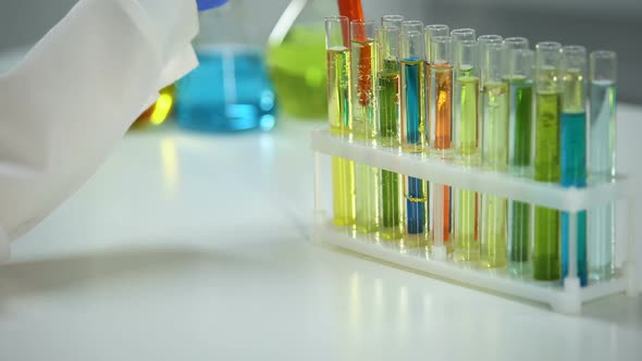 Chemist Checking Tube With Orange Liquid, Dyestuff Agent, Washing Substance