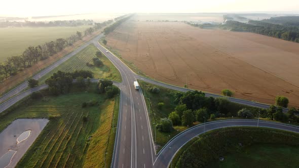 Aerial Drone View Flight Over Automobile Road Between Agricultural Wheat Fields