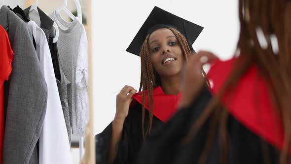 Woman Put on Graduate Cap and Gown and Look in Mirror Spbi