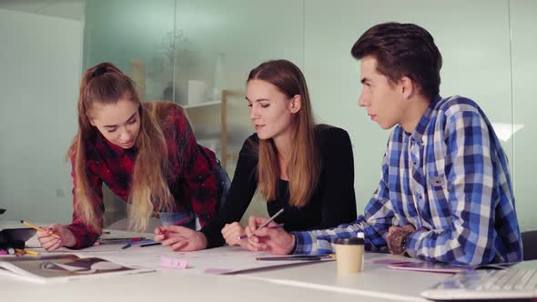 Creative Business Team of Three People Meeting in a Modern Office and Discussing Business Ideas