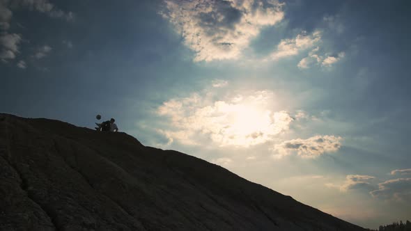 A Young Boy on Top of a Mountain Performs Tricks with a Soccer Ball