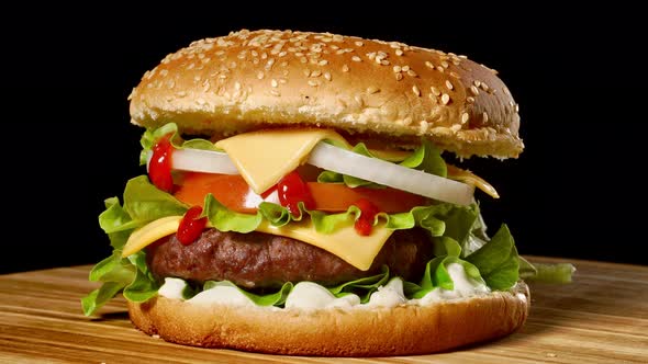 Great Burger with Beef Cutlet, Tomatoes, Mushrooms and Cucumbers with Melted Cheese Rotates on a