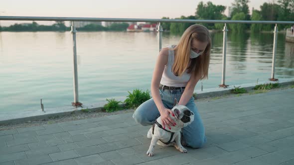 Young Woman Walking with French Bulldog in Park.