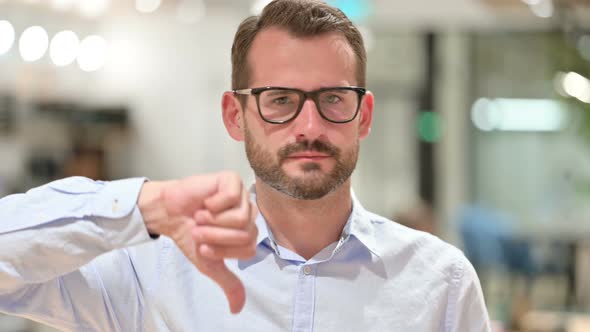 Portrait of Disappointed Businessman Doing Thumbs Down 