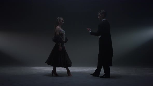 Dance Couple Holding Hands on Dark Stage