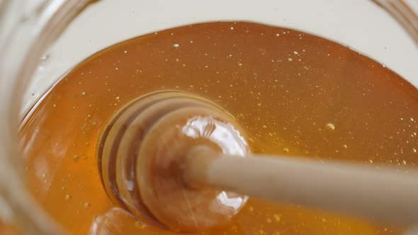 Sticky honey dipper sinked  in sweet food substance 4K 2160p 30fps UltraHD footage - Spiral kitchen 