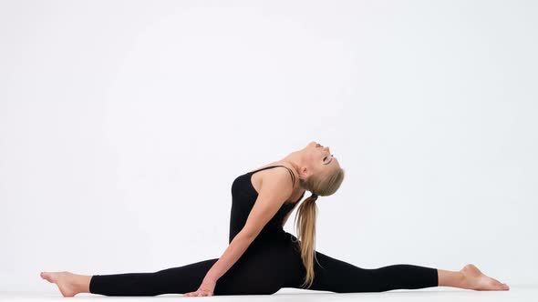 Young woman demonstrates a yoga pose on a white background.