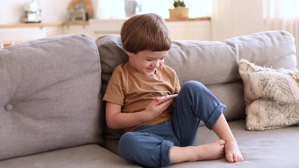 Preschool Caucasian Boy Watches Cartoons on Smartphone