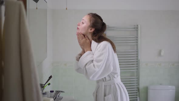 Side View Portrait of Young Slim Woman Washing Face with Clear Water in Bathroom at Home in the