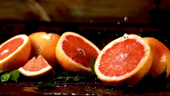 Super Slow Motion on Fresh Pieces of Grapefruit Drop Drops of Water