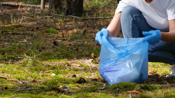 Hands of a Woman in Gloves Closeup. Girl Volunteer Collects Garbage, Putting in a Biodegradable Bag.