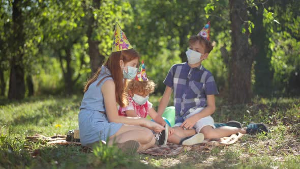 Side View Caucasian Redhead Teenage Girl in Covid Face Mask Talking Sitting with Friends Siblings on