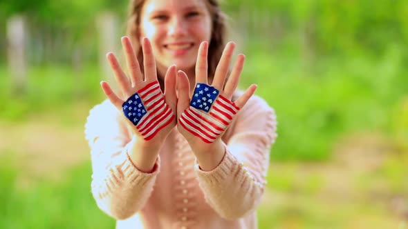 Cute Teenager Girl Waving Greeting with Painted Hands in American Flag Color