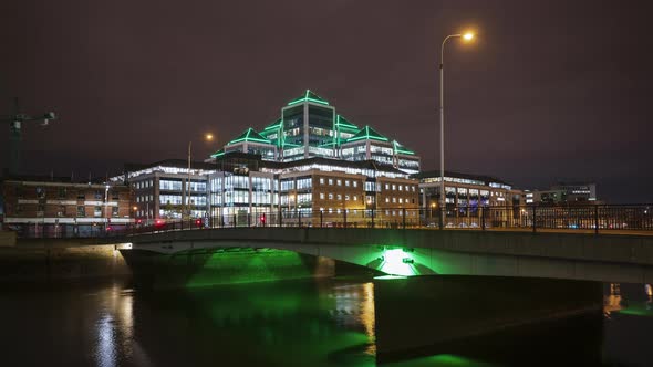 Time lapse of Ulster Bank building illuminated at night with traffic on the bridge over Liffey river