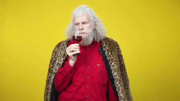 Confident Serious Rich Senior Man Examining Red Wine in Drinking Glass