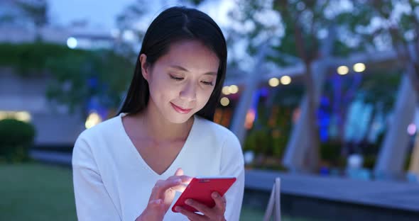 Woman use of mobile phone in Hong Kong at night