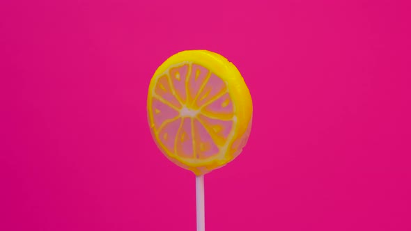 Lollipop Spins On A Stick On A Pink Background, Lemon Candy On A Stick. Caramel Sweetie