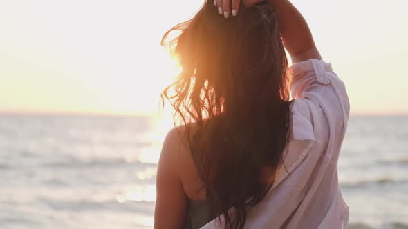 Portrait of a Beautiful Woman in the Background of the Setting Sun. Hair in the Wind. Portrait of a