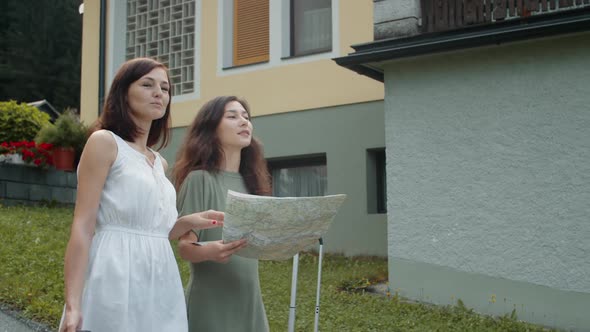 Girlfriends with Suitcases Using Paper Map