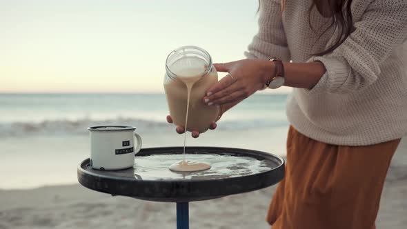 Slow motion footage of a Woman Baking Pancakes in a Sheet Pan in broad daylight at the beach