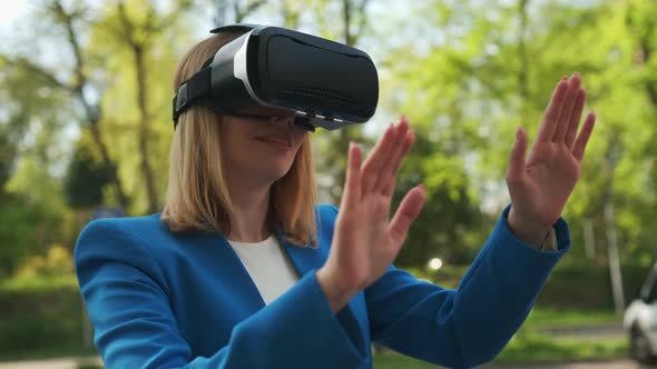 Business Woman Using VR Goggles Touching the Simulation Screen in the Park