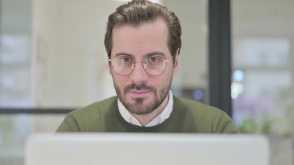 Close Up of Young Businessman with Laptop Showing Thumbs Up