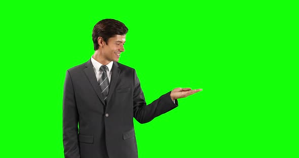 Side view of Caucasian man holding his hand for copy space with green screen