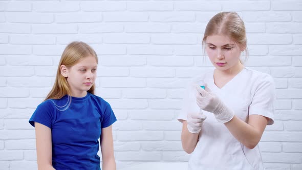 Young Nurse Dials Medication Into Syringe and Giving Injection for Girl