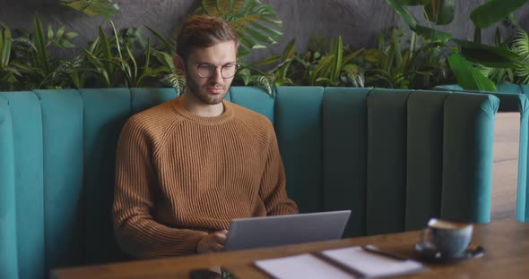 Man Who Sits in Cafe Using the Laptop for the Remote Work