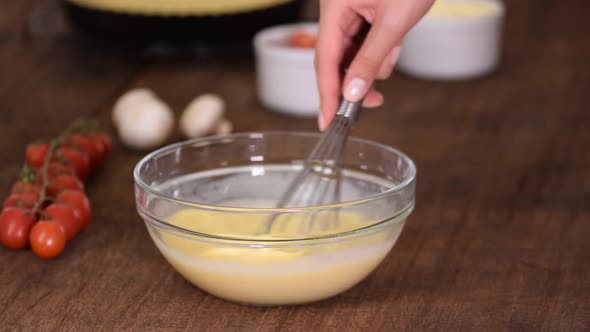 Whisking Fresh Raw Chicken Eggs in a Glass Bowl