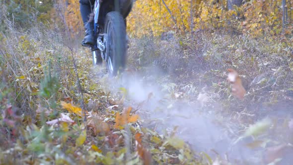 Motorcyclists Rides on Trail in Autumnal Forest