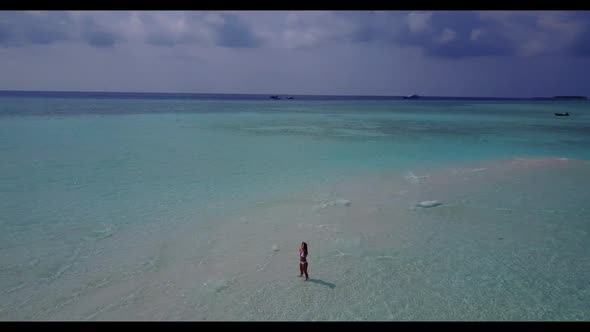 One girl posing on perfect resort beach voyage by blue sea with white sand background of the Maldive