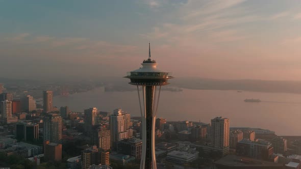 Orbiting aerial the Space Needle with a smoke filled sunset over the Puget Sound as the backdrop.
