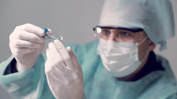 The Laboratory Assistant Holds a Vial of COVID-19 Coronavirus Vaccine in His Hand. Vaccine Against