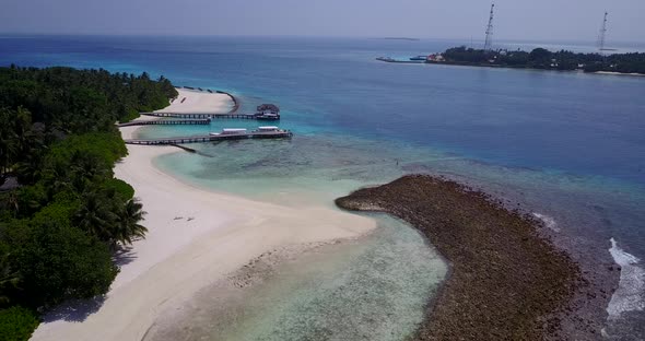 Natural overhead travel shot of a sandy white paradise beach and aqua turquoise water background 