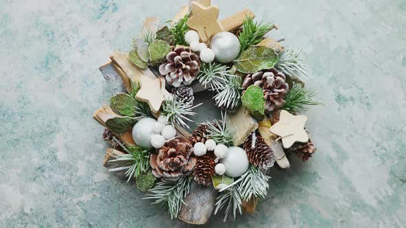 Typical Beautiful Christmas Wreath Made with Pines, Wooden Ornaments and Leafs