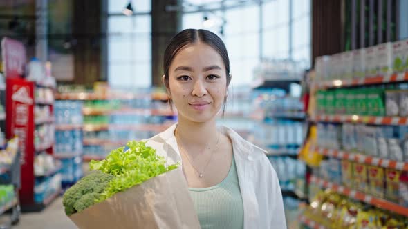 Asian Woman Enjoys Spending Pastime Shopping in Market