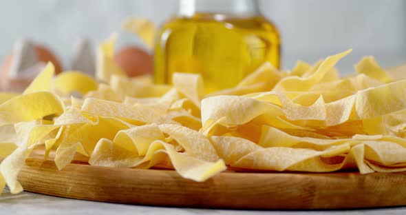 Dry Fettuccine Pasta Slowly Rotates on a Cutting Board