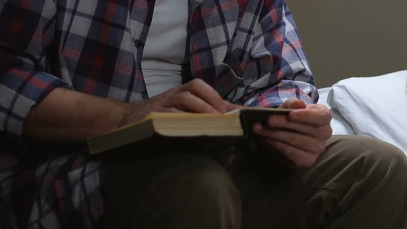 Male Prisoner Reading Holy Book in Jail Cell, Searching for Answers, Praying