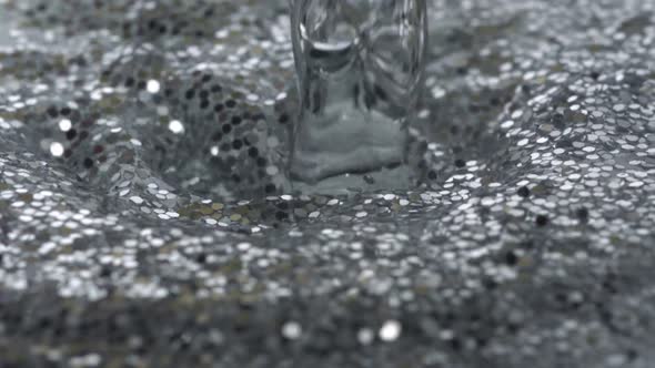 Pouring water into water filled with glitter, Slow Motion