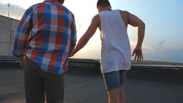 Unrecognizable Gay Couple Standing on Roof and Rejoices Life with Cityscape at Background
