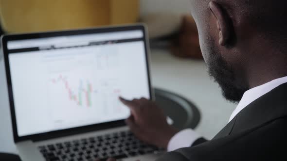 Black Businessman Using Laptop for Analyzing Data Stock Market Stock Exchange Trading Online