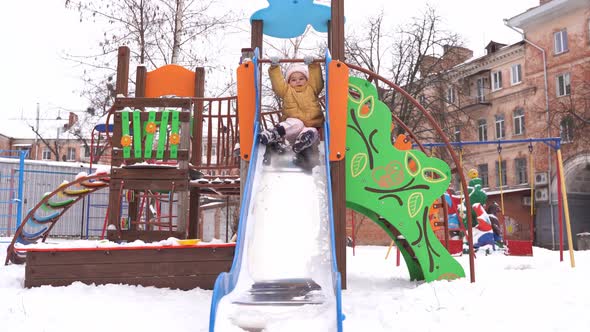 Toddler Girl Playing on Playground in Winter