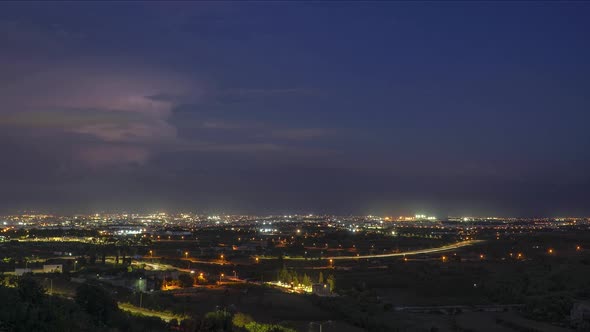 Night timelapse of city scape with lightening in the background