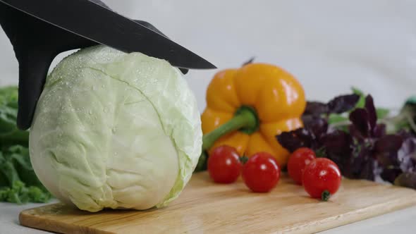 Chef Cuts the Half Cabbage with a Knife in Slow Motion Making a Salad Fresh Vegetables on a Cutting