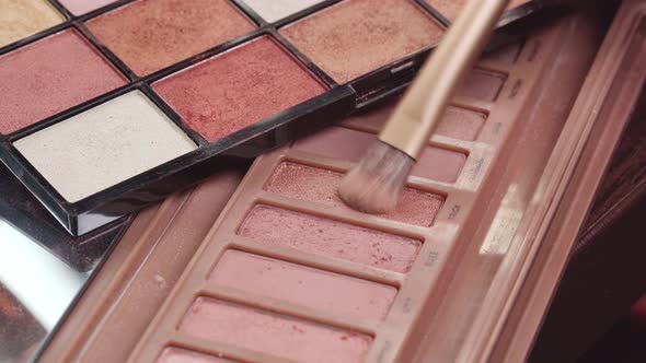 Close Up of Make Up Brush and Eyeshadows Palette on Vanity Table