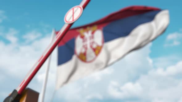 Closing Barrier with STOP CORONAVIRUS Sign Against the Serbian Flag alt