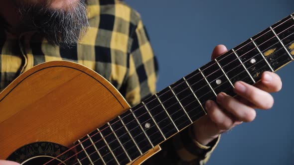 Man Play Acoustic Guitar at Blue Wall