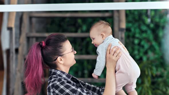 Side View Happy Hipster Young Mother Playing with Little Son Admiring and Kissing Him Medium Closeup