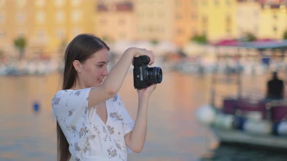 Female Photographer is Taking Photo of City Near Sea